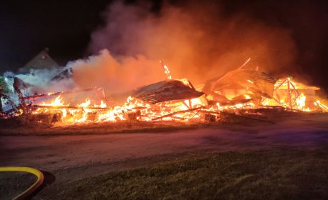 Obraz zawierający ogień, palące się drewno, na wolnym powietrzu, dużo dymu.