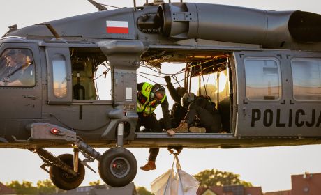 Obraz zawierający transport, helikopter policyjny, statek powietrzny, na zdjęciu widoczne są trzy osoby.